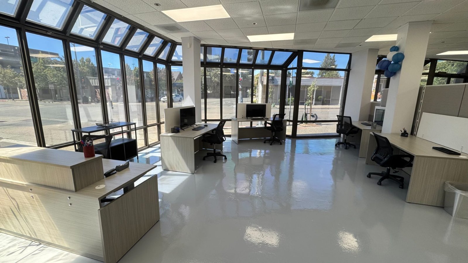Welcome area and front desk with floor-to-ceiling windows at the B-OSS hub in downtown Santa Rosa