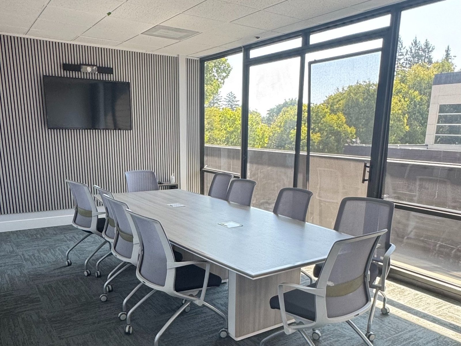 Boardroom meeting space with video screen and city views at B-OSS in downtown Santa Rosa